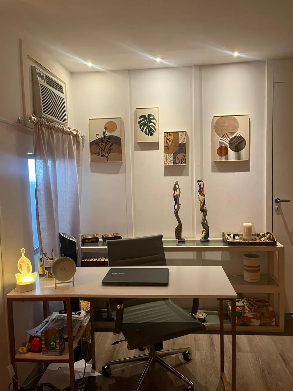 Mesa de trabalho do consultório, com iluminação natural e decoração acolhedora